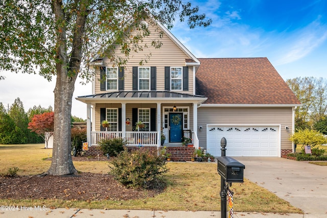 front of property with covered porch, a front yard, and a garage