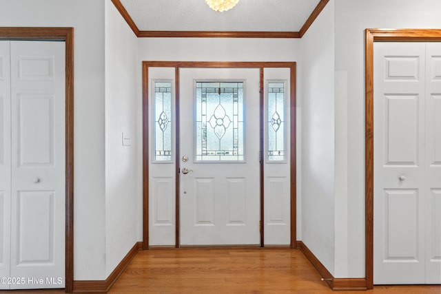 entrance foyer featuring crown molding and light wood-type flooring