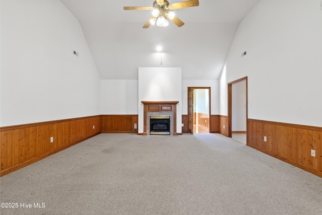 unfurnished living room featuring lofted ceiling, a tiled fireplace, light carpet, and ceiling fan