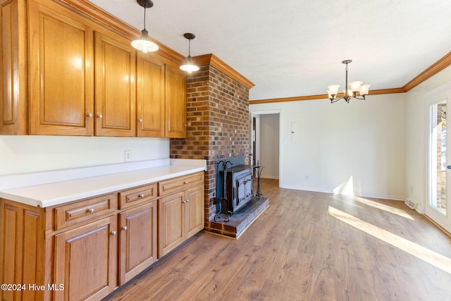 kitchen with crown molding, hardwood / wood-style floors, a healthy amount of sunlight, and decorative light fixtures