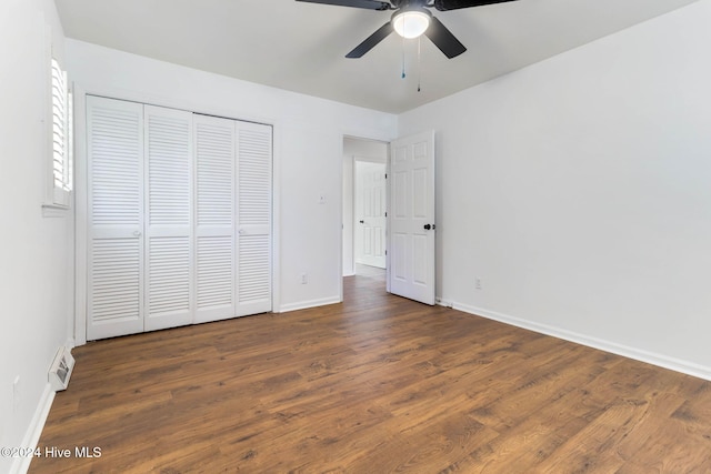 unfurnished bedroom with ceiling fan, a closet, and dark hardwood / wood-style floors