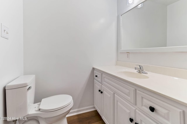 bathroom with hardwood / wood-style floors, vanity, and toilet