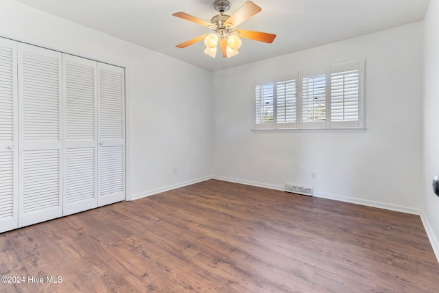 unfurnished bedroom with ceiling fan, a closet, and hardwood / wood-style flooring