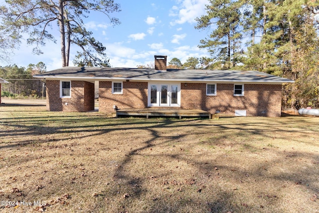 rear view of property featuring a yard and a deck