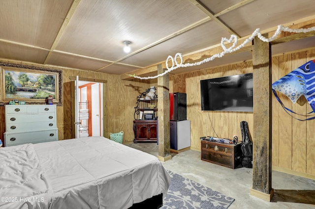 bedroom featuring concrete floors and wood walls