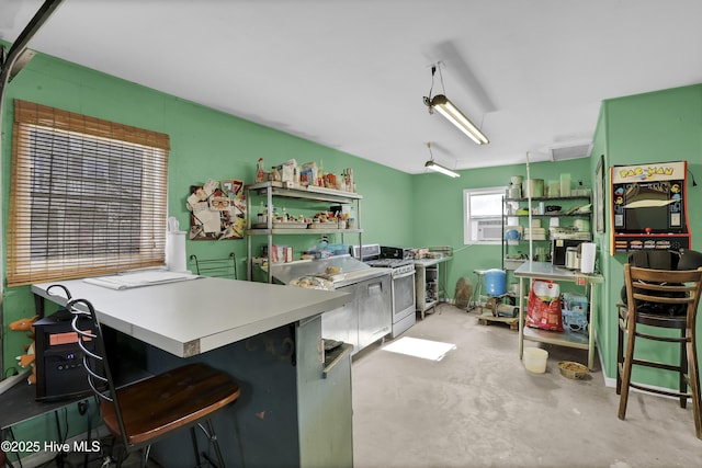 kitchen with a kitchen breakfast bar, gas stove, kitchen peninsula, and cooling unit