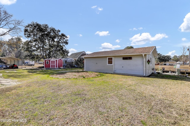 rear view of property featuring a lawn, a storage shed, an outbuilding, and a carport