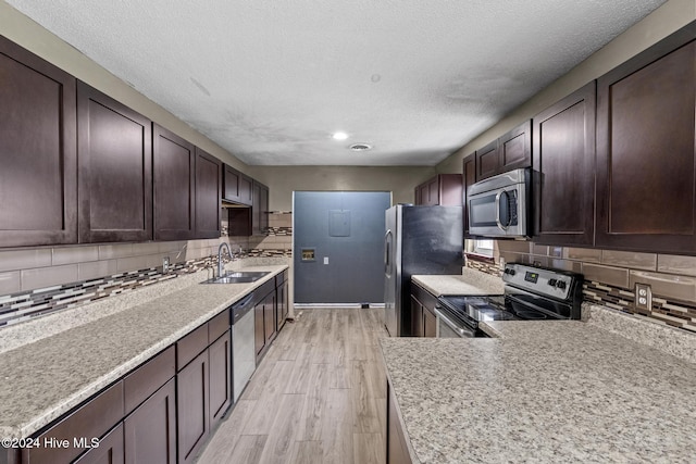 kitchen featuring light hardwood / wood-style floors, sink, stainless steel appliances, and tasteful backsplash