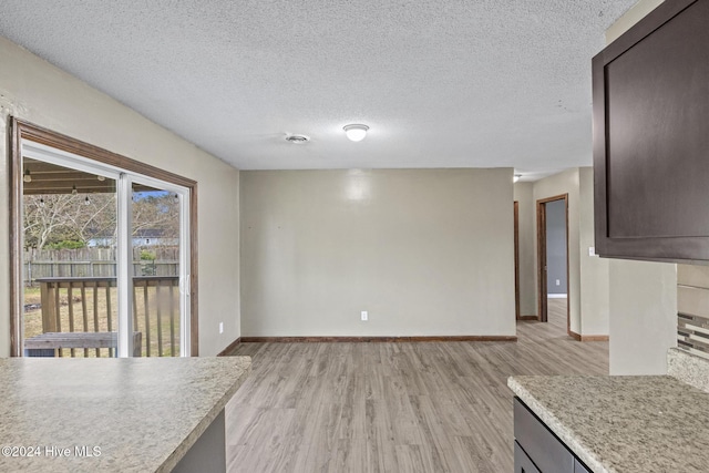 interior space with a textured ceiling and light wood-type flooring