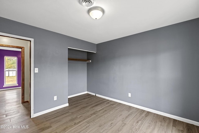 unfurnished bedroom featuring hardwood / wood-style flooring and a closet