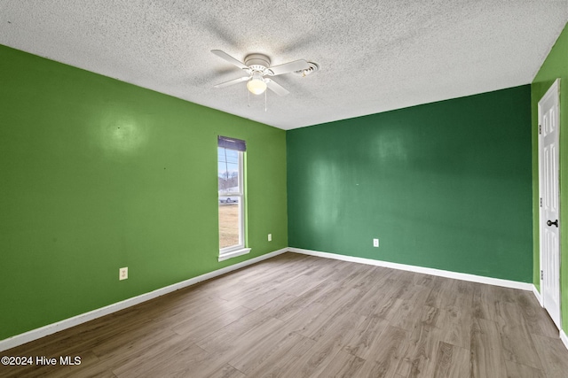 unfurnished room featuring ceiling fan, light hardwood / wood-style floors, and a textured ceiling