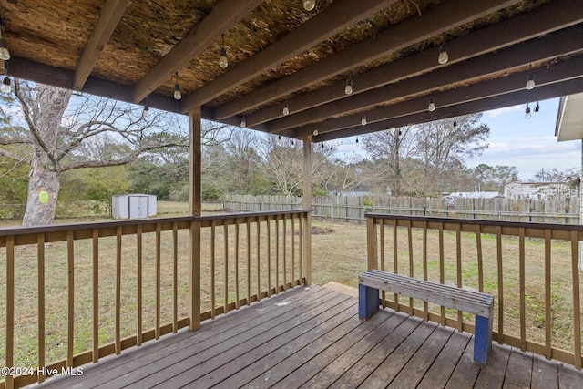 wooden deck with a lawn and a shed