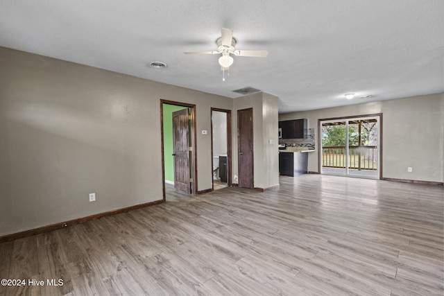 unfurnished living room with a textured ceiling, light hardwood / wood-style flooring, and ceiling fan