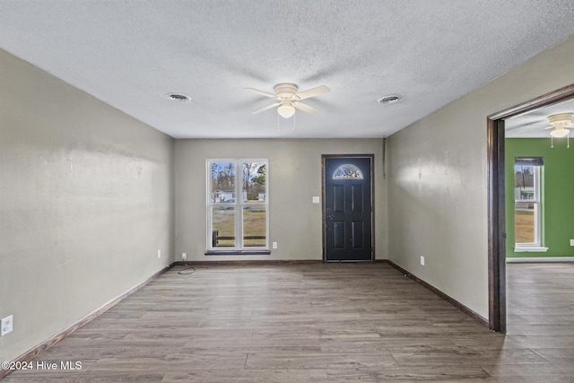 entrance foyer featuring ceiling fan, light hardwood / wood-style flooring, and a textured ceiling