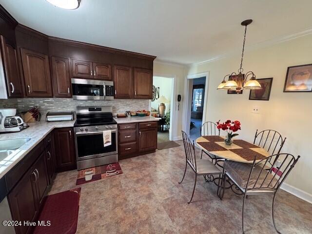 kitchen featuring backsplash, dark brown cabinetry, stainless steel appliances, decorative light fixtures, and a notable chandelier