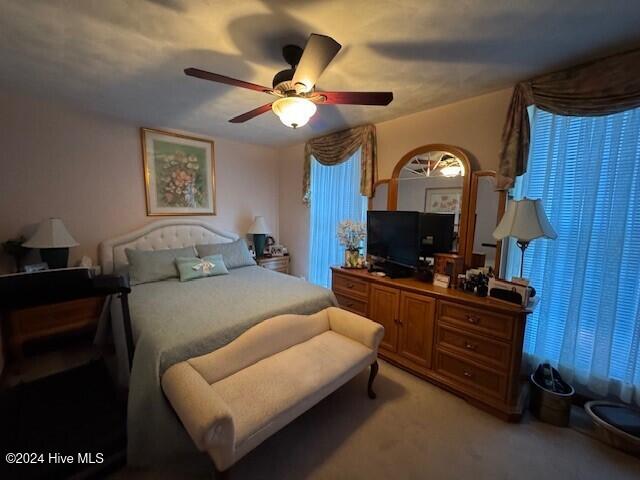 bedroom featuring ceiling fan and light carpet