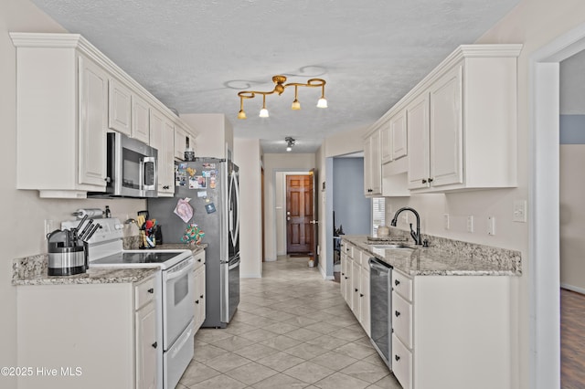 kitchen featuring white cabinets, sink, light tile patterned floors, light stone counters, and stainless steel appliances