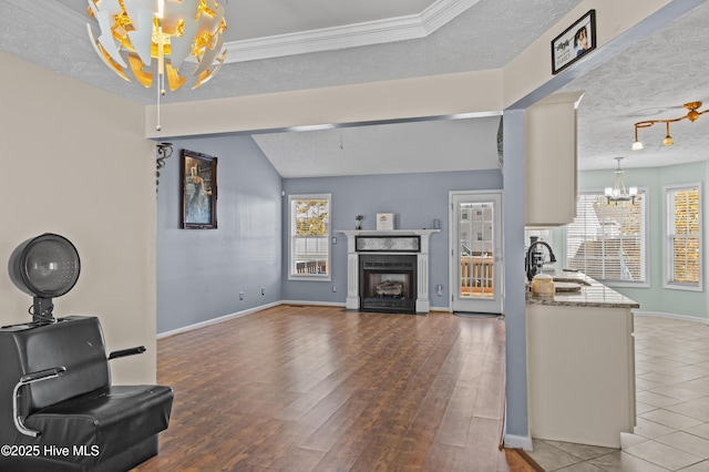 living room featuring a textured ceiling, vaulted ceiling, sink, wood-type flooring, and a chandelier