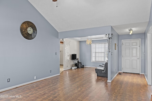 living room with hardwood / wood-style floors and ceiling fan with notable chandelier