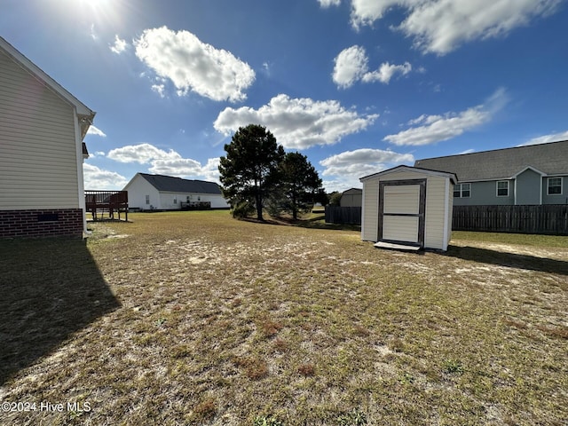 view of yard with a deck and a storage unit