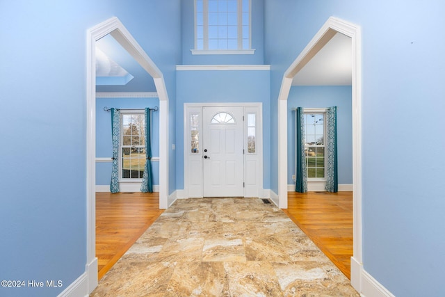 foyer entrance featuring hardwood / wood-style flooring and crown molding