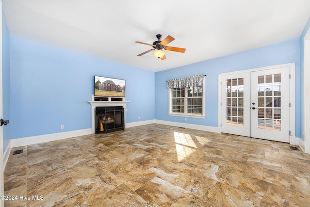 unfurnished living room featuring ceiling fan and french doors