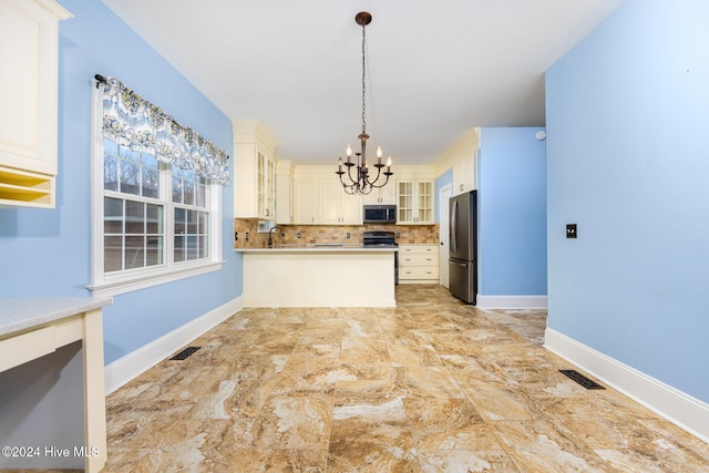 kitchen with appliances with stainless steel finishes, decorative light fixtures, an inviting chandelier, and tasteful backsplash