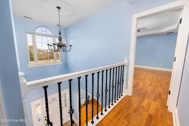 hall featuring a notable chandelier and light wood-type flooring