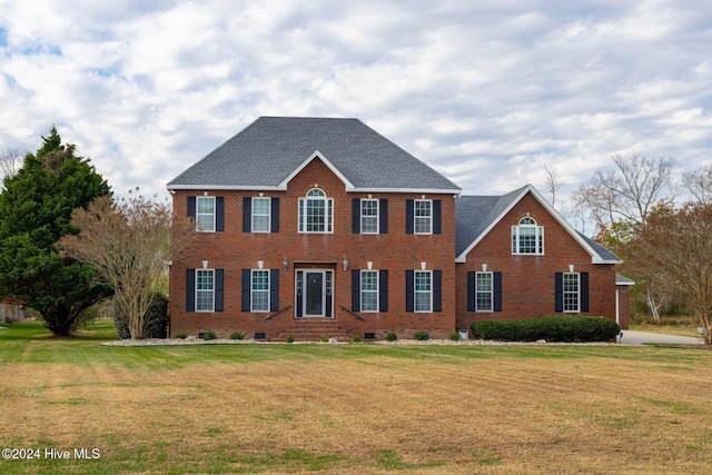 colonial inspired home featuring a front lawn