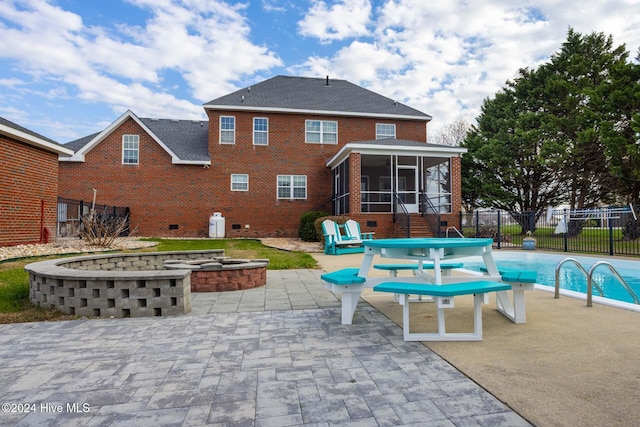 back of property featuring a fenced in pool, a sunroom, and a patio