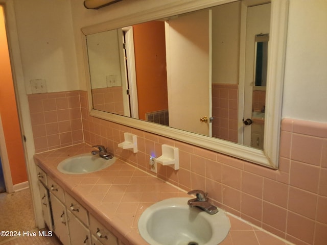 bathroom featuring vanity and tile walls