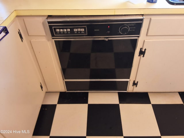 room details featuring white cabinets and black oven