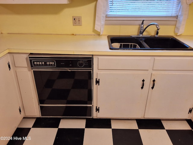 kitchen featuring white cabinets, dishwasher, and sink