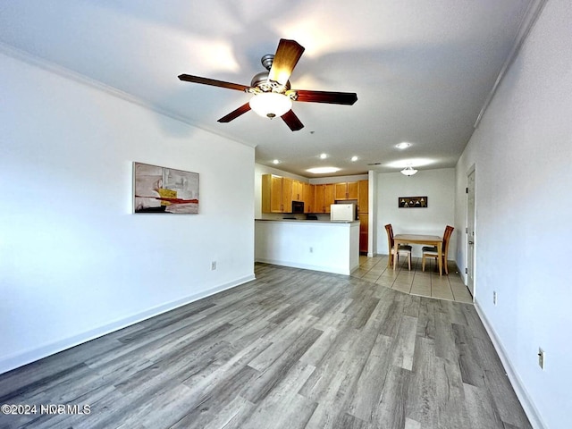 unfurnished living room featuring ceiling fan, light hardwood / wood-style floors, and ornamental molding