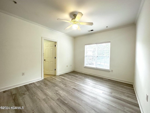 spare room featuring ceiling fan, ornamental molding, and light hardwood / wood-style flooring