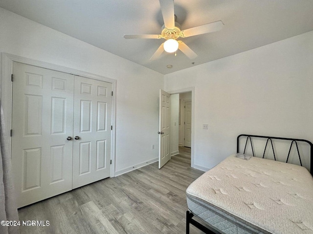 bedroom with ceiling fan, a closet, and light hardwood / wood-style flooring