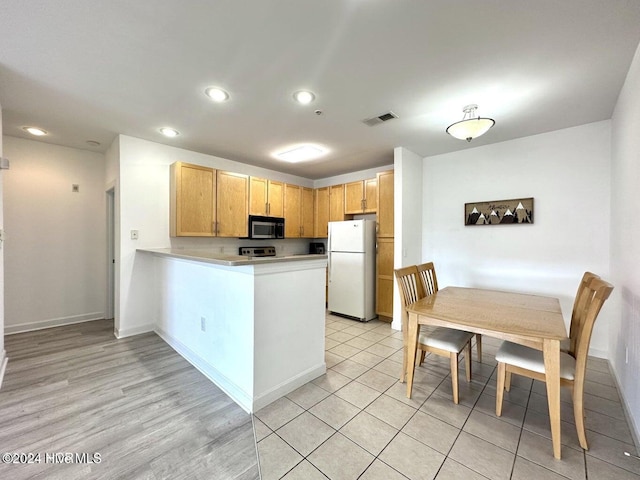 kitchen featuring kitchen peninsula, light hardwood / wood-style flooring, white fridge, and light brown cabinetry