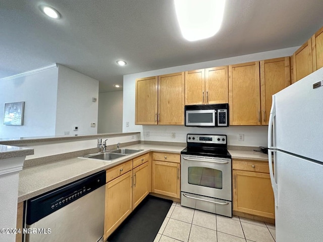 kitchen with light brown cabinetry, sink, light tile patterned floors, and stainless steel appliances