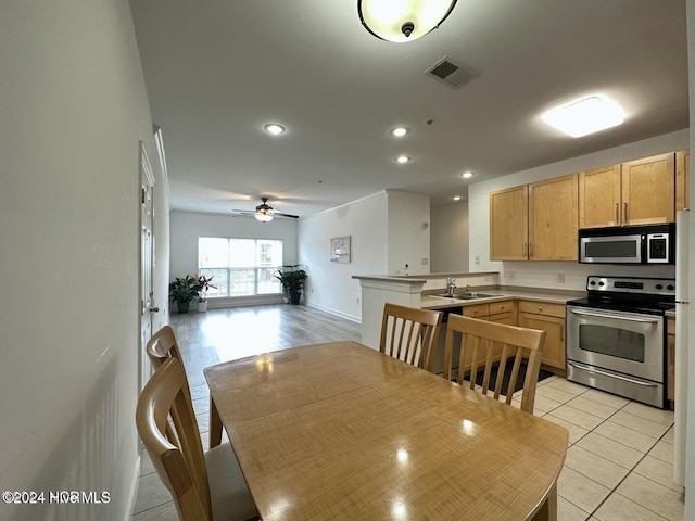 kitchen featuring kitchen peninsula, appliances with stainless steel finishes, ceiling fan, light brown cabinets, and light tile patterned flooring