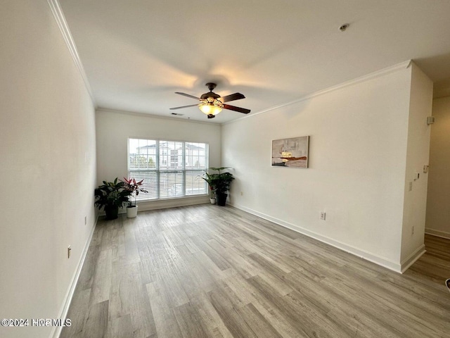 empty room featuring ceiling fan, light hardwood / wood-style floors, and ornamental molding