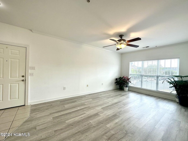 empty room featuring light wood-type flooring, ceiling fan, and ornamental molding