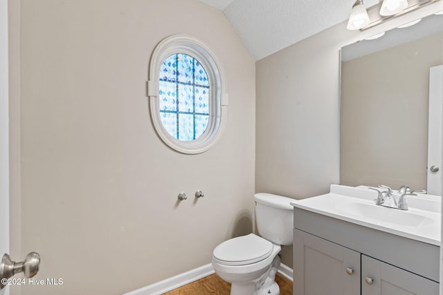 bathroom with vanity, lofted ceiling, toilet, a textured ceiling, and wood-type flooring