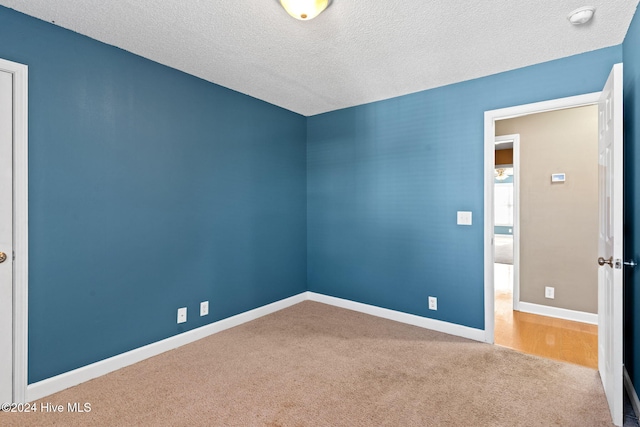 carpeted spare room with a textured ceiling