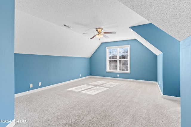 bonus room with a textured ceiling, ceiling fan, lofted ceiling, and carpet floors