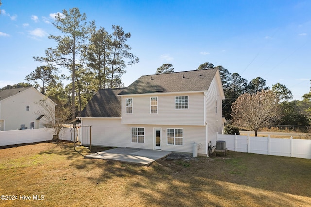 rear view of property with a yard, cooling unit, and a patio