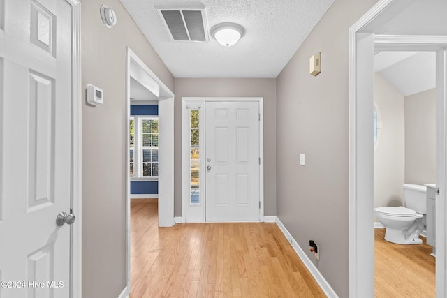 entryway featuring a textured ceiling and light hardwood / wood-style floors