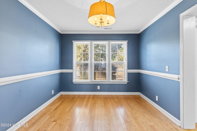 unfurnished room featuring a chandelier, wood-type flooring, a textured ceiling, and crown molding