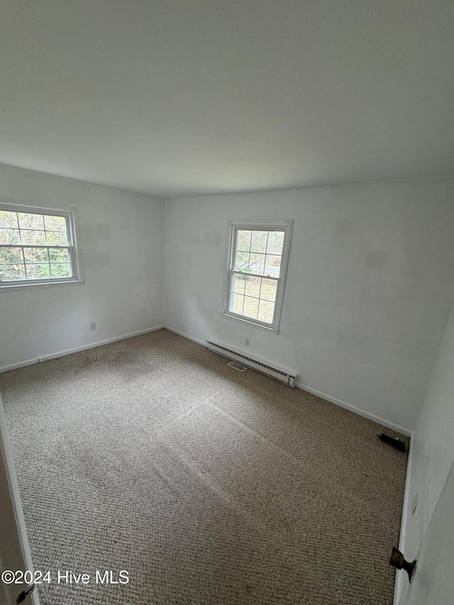 empty room with carpet floors and a baseboard radiator