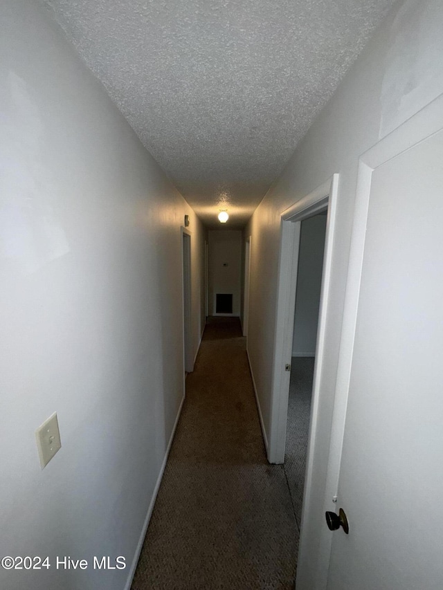 corridor featuring carpet and a textured ceiling