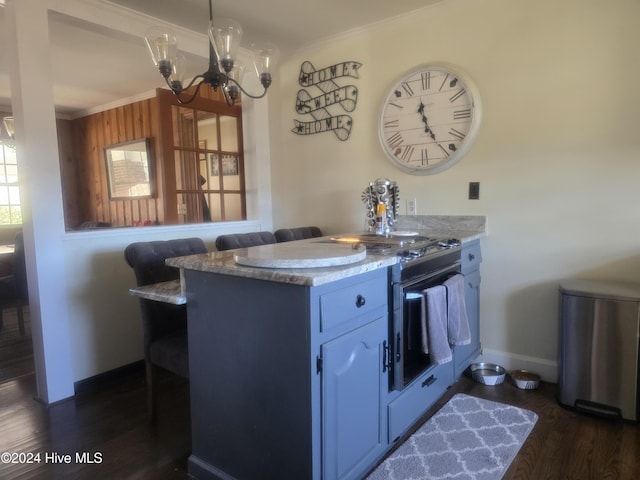 kitchen with kitchen peninsula, dark wood-type flooring, crown molding, white cabinets, and a chandelier